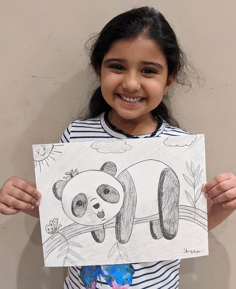 Shreeja pathak is proudly holding the pencil sketch of a cute baby panda which she drew at Nimmy's art classes