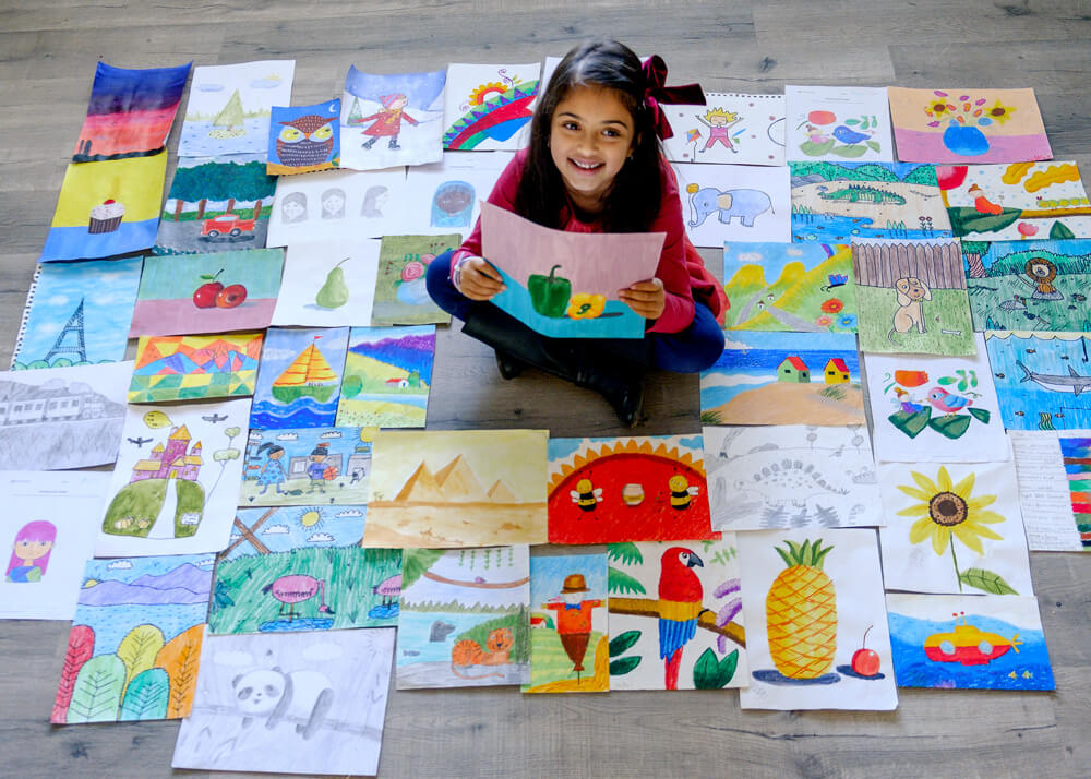 Anika with all her artworks in multiple mediums completed at Nimmy's Art online art classes for kids at Katy, Texas.