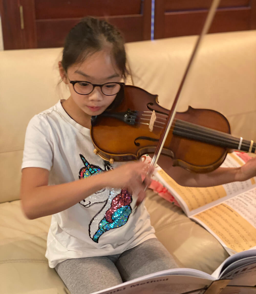 Abigail playing the violin with the help of her notes