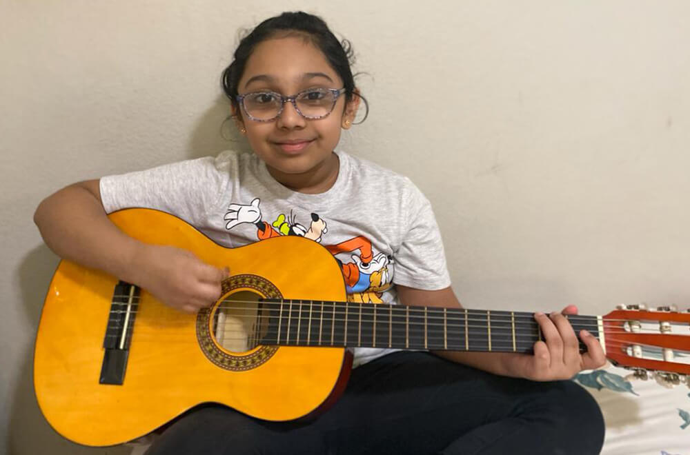 A student at Nimmy's Art playing the guitar during her free time.