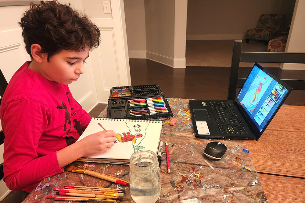 Image of a young kid participating in a Nimmy's Art live online class, learning and exploring their creativity through art