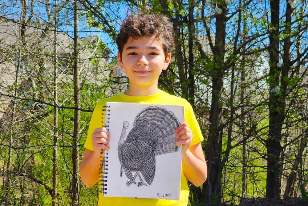 In the charcoal drawing, a student of Nimmy's art class is seen holding their artwork of an ostrich.