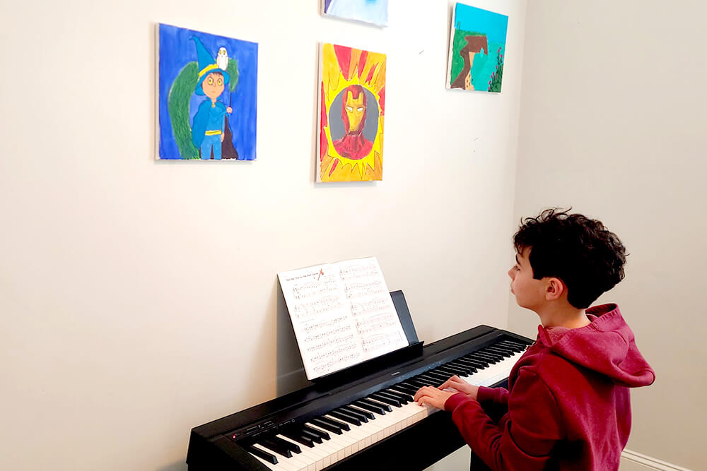 A multi-talented young visual artist showcasing their musical skills by playing the piano