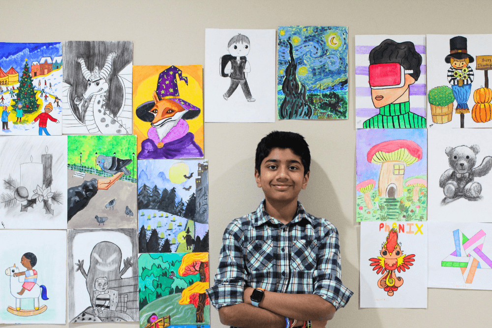 A young artist proudly showcasing his vibrant artworks