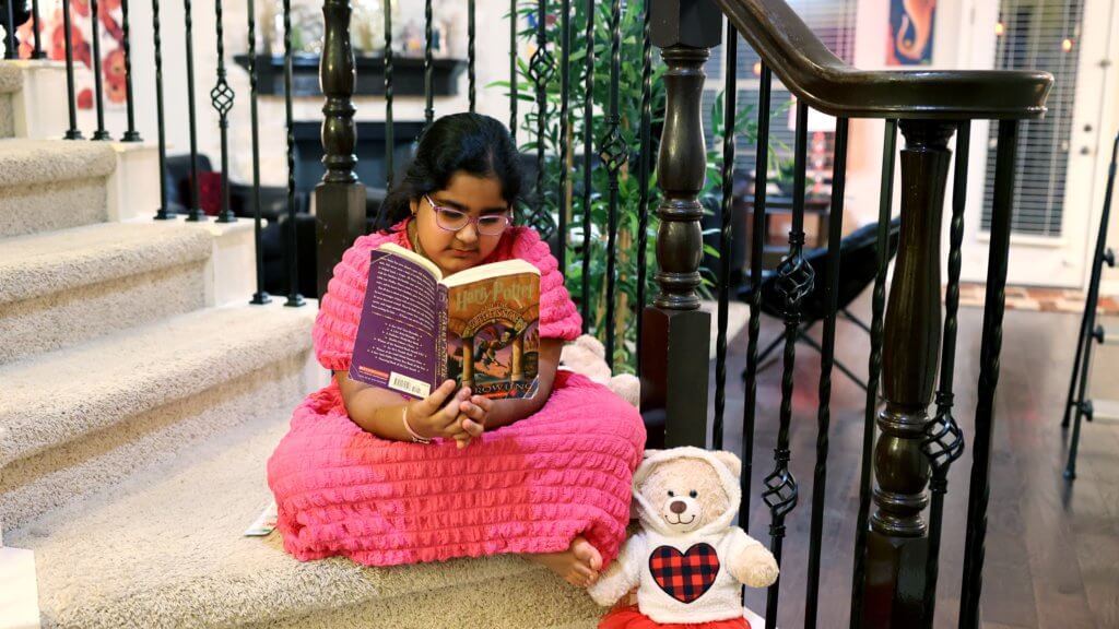 An artist sits comfortably, engrossed in reading one of her favorite books.