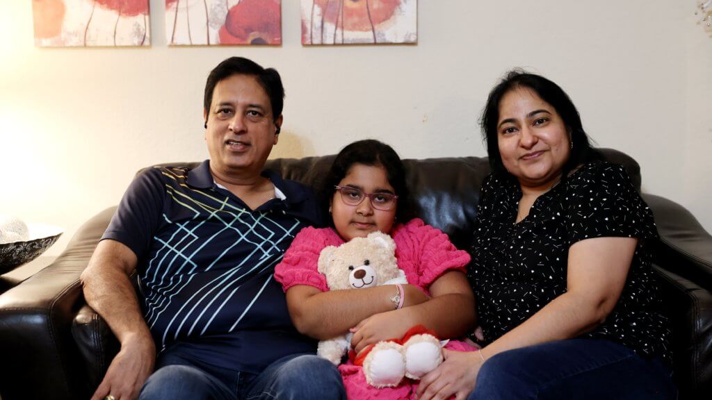 Artist Spotlight and her parents sit together on the couch, showing their support.