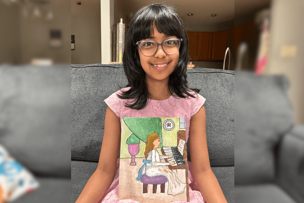 Aadhya holding her acrylic master study painting of Young Girls at the Piano by Renoir.