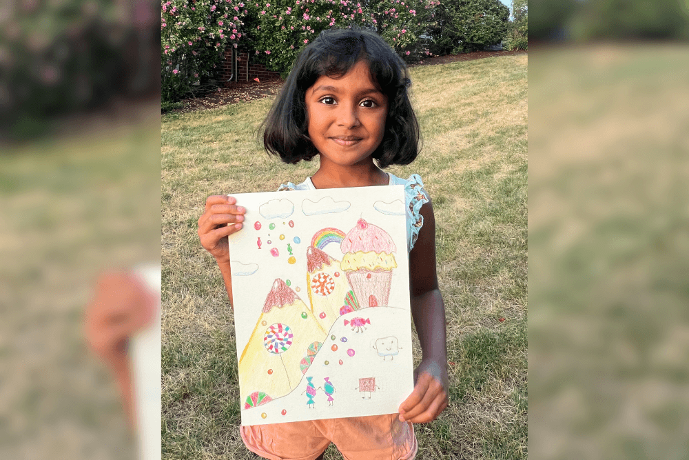 Charvi holding her colorful Candyland drawing made with colored pencils. From summer art camp.