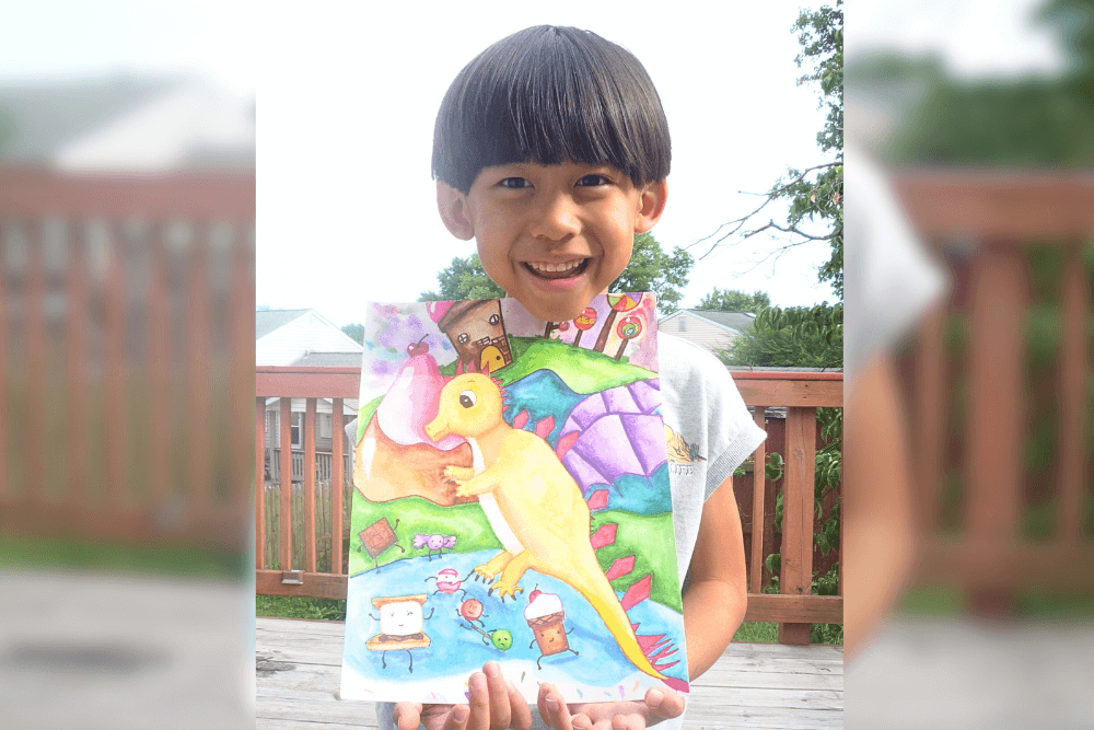 Gareth holding his pencil drawing Cute Dragon Friend, a character study of a playful dragon created at Summer Art Camp 2025.