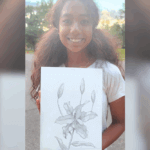 Young artist Harene holding her pencil drawing of lilies, showcasing a study of texture in botanical art.