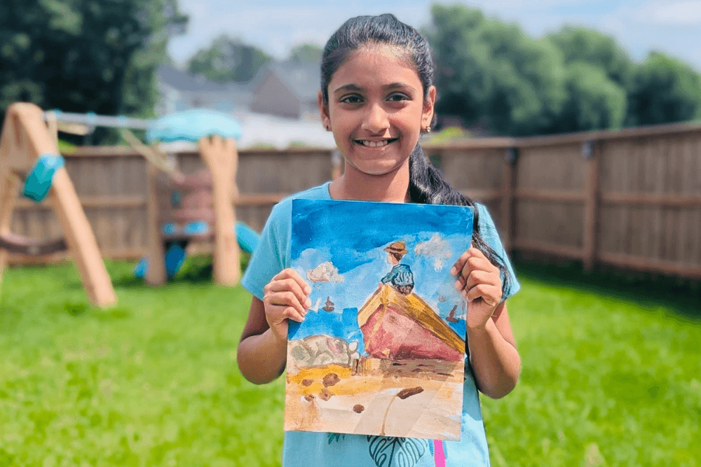 Joann holding her gouache master study Dad’s Coming! inspired by Winslow Homer. From summer art camp.