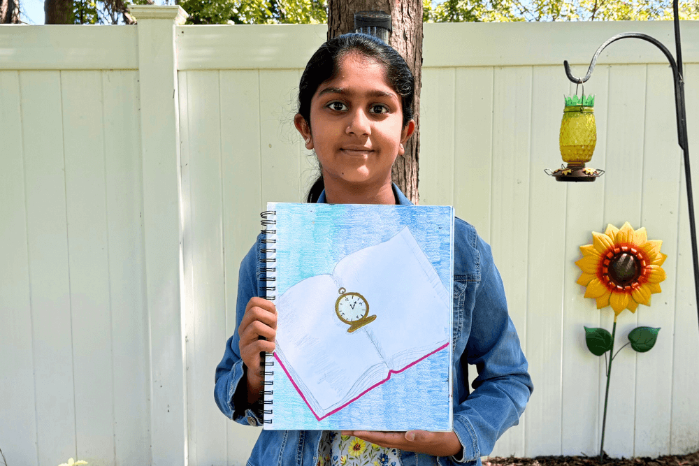 Navya holding her oil pastel artwork of a neon sign board with bold colors and glowing effects.