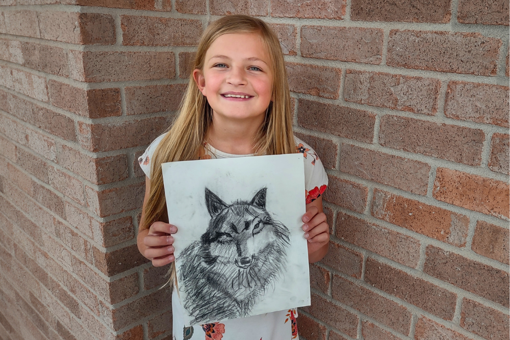 Charcoal pencil drawing of a majestic wolf created by young artist Olivia, showcasing fine shading and realistic detail.