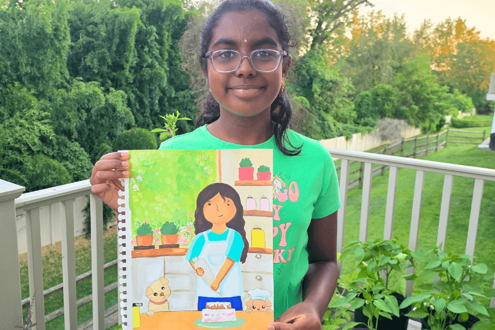 Sananda holding her acrylic painting Baking Time showing a girl baking a cake in the kitchen with a puppy beside her.