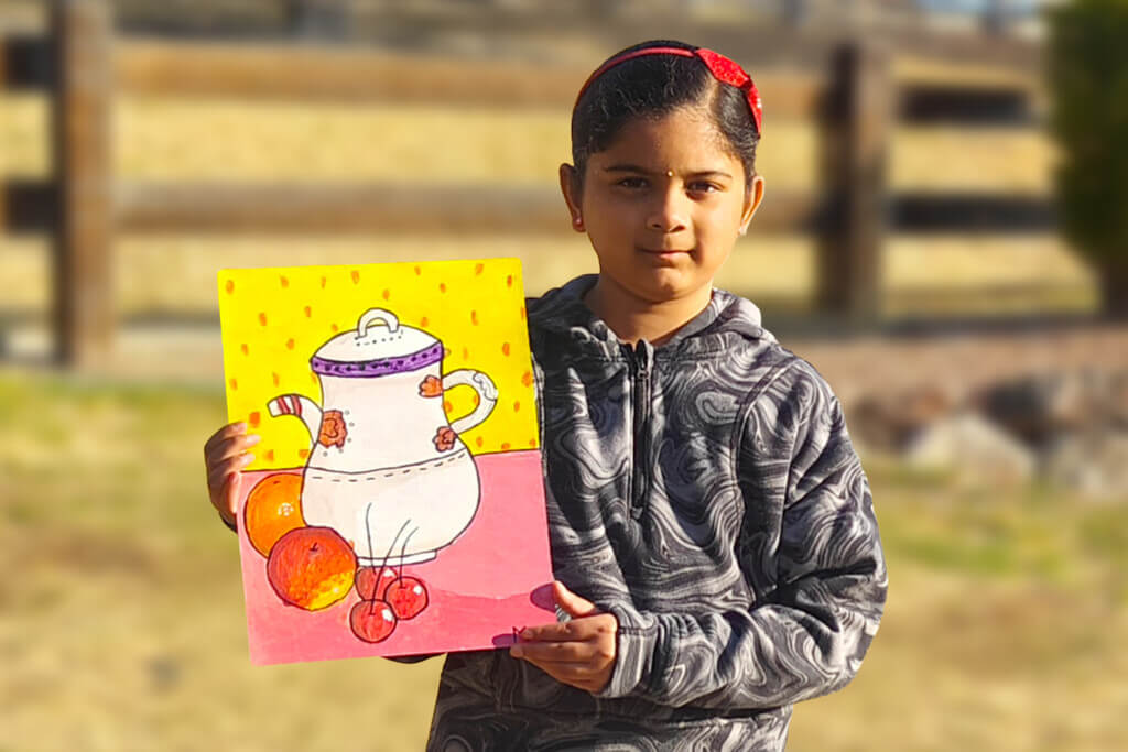 Mithra, a 7-year-old girl, stands outdoors holding her painting of a teapot and fruits, inspired by a classic still life artwork.