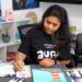 Nimmy, an art instructor, painting with vibrant acrylic colors on a canvas.